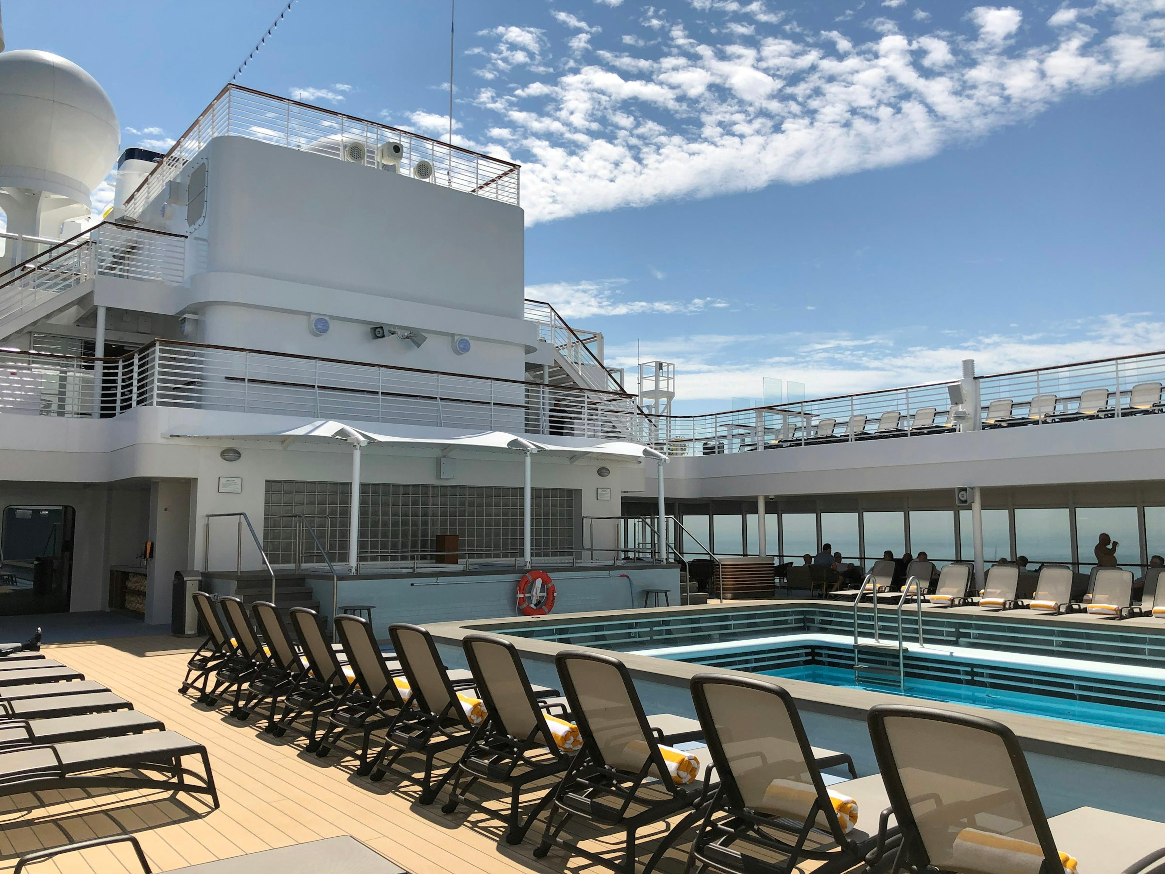 The pool and lounge chairs on the deck of a cruise ship