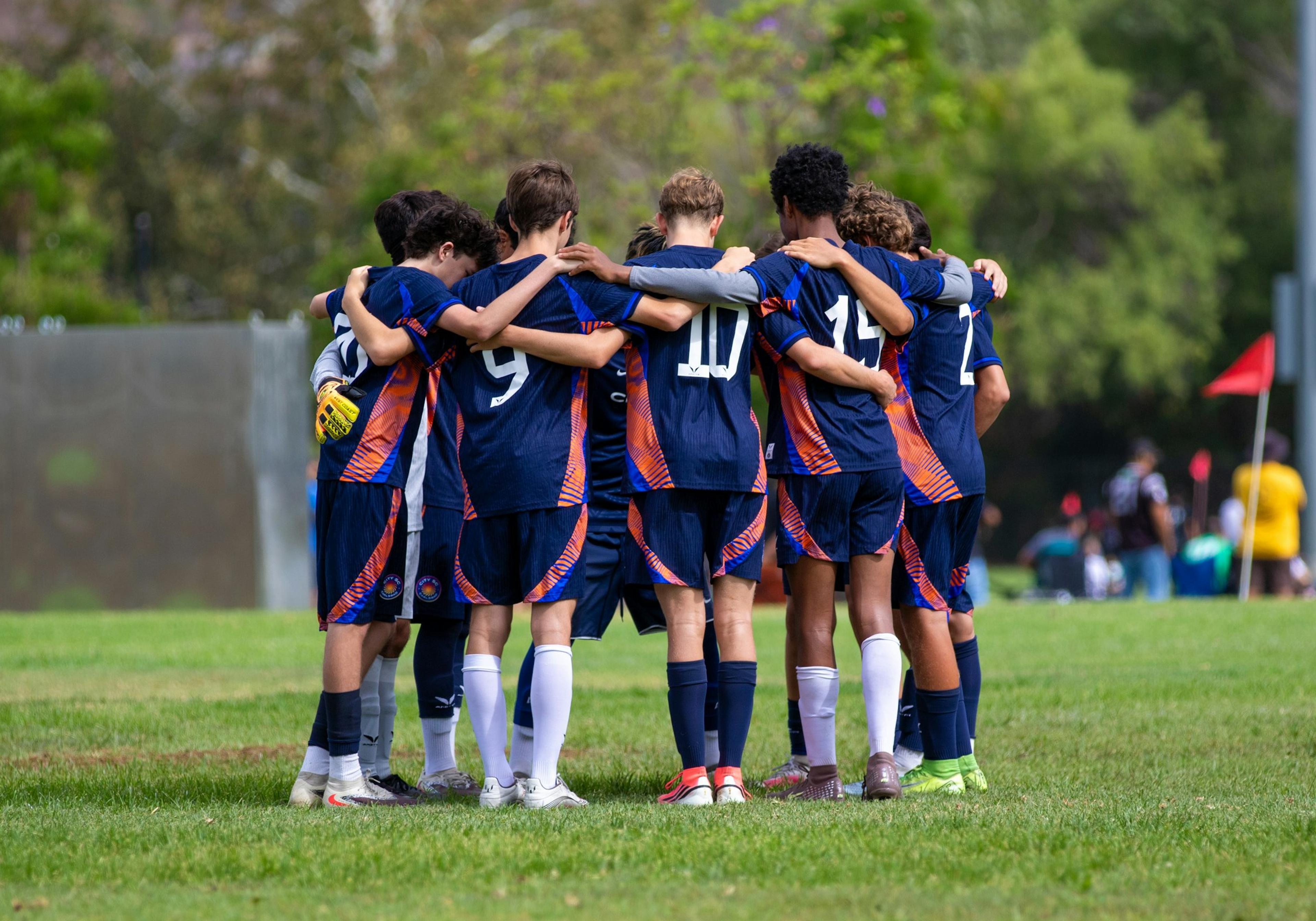 A soccer team huddled on the field