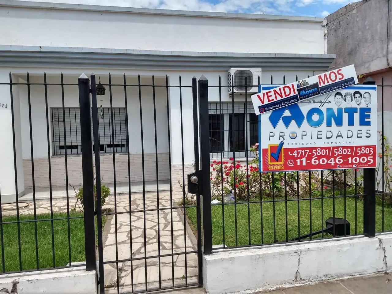 Casa con jardín y cartel de Vendimos de Rodolfo Monte Propiedades
