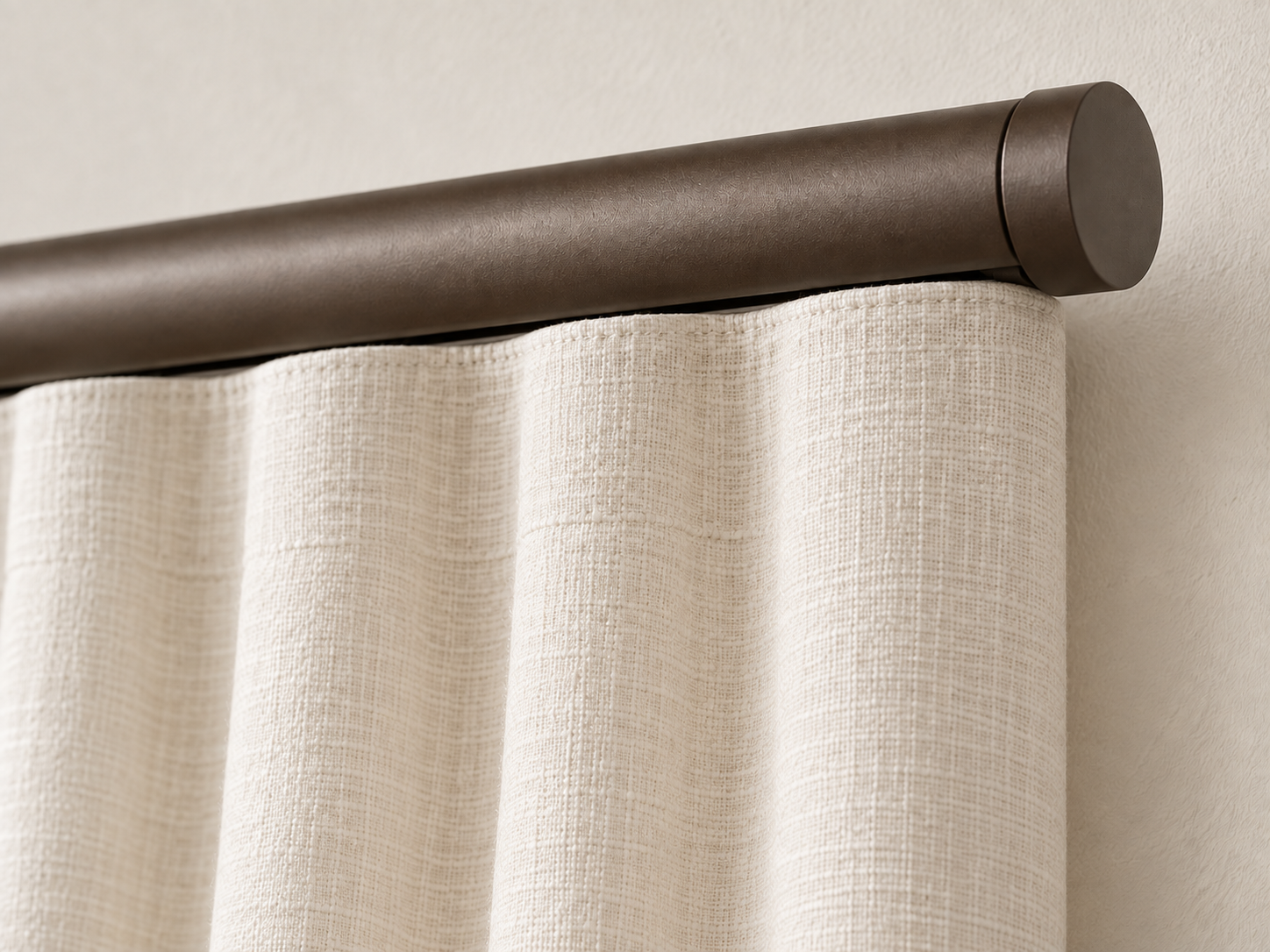 Close-up of a Bronze K-Rail and ivory linen curtain heading with concealed attachment