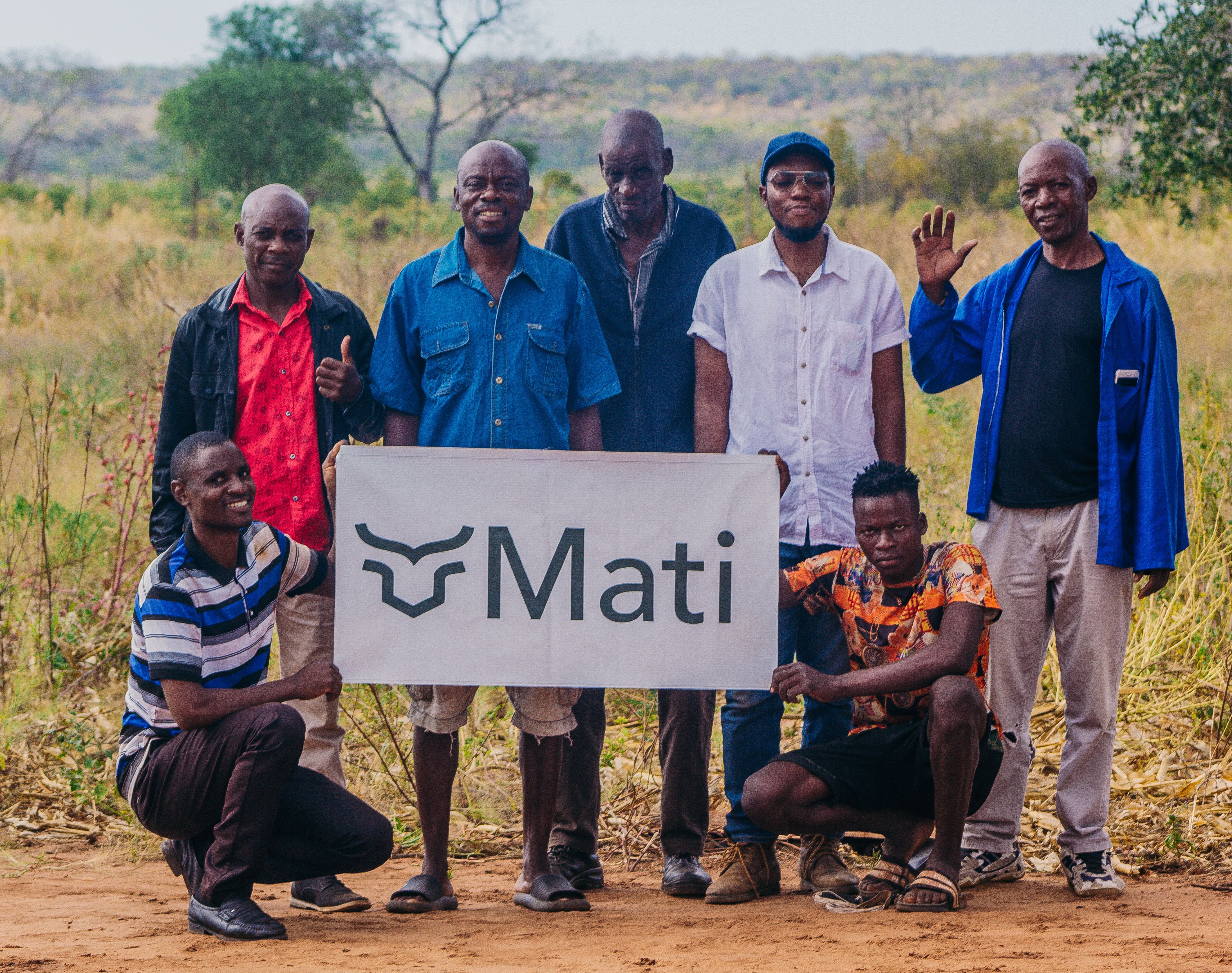 Farmers holding a sign with the Mati Carbon logo