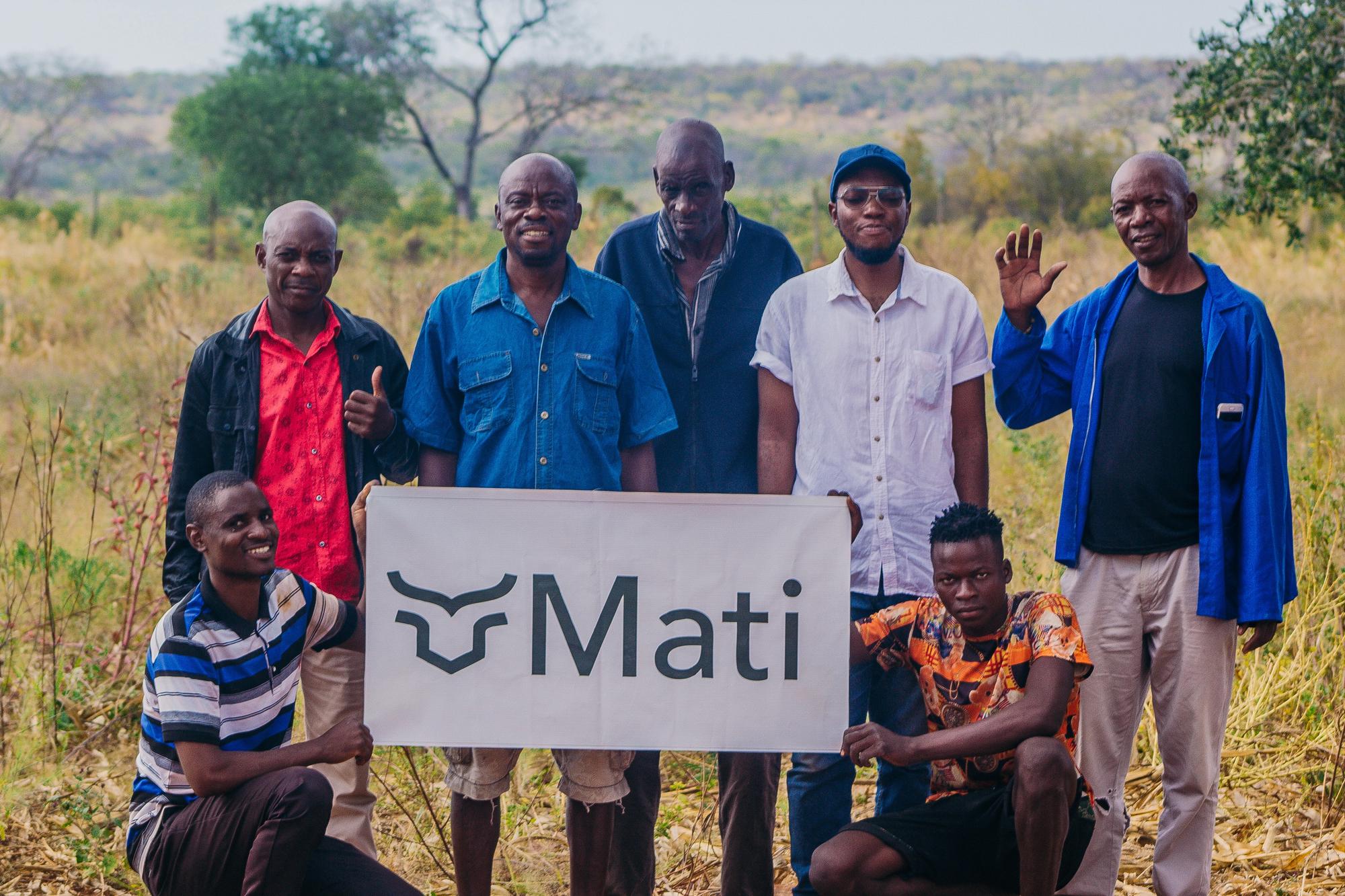 Farmers holding a sign with the Mati Carbon logo