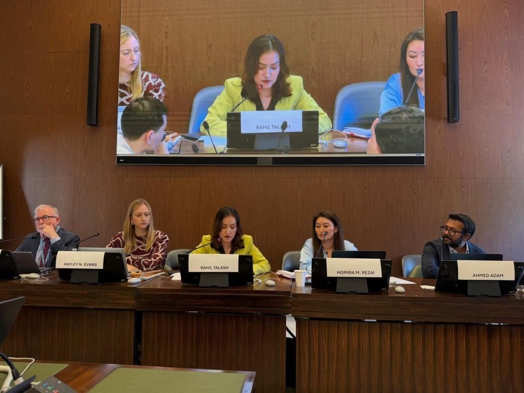 The side event panel at the Palais des Nations: Richard Bennett, Hayley N. Evans, Rahil Talash speaking, Homira M. Rezai and moderator Ahmed Adam, with the room screen showing Rahil Talash