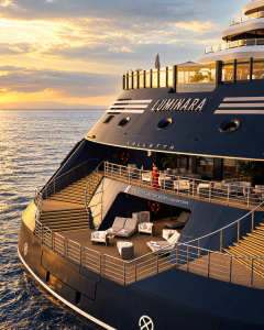 Luminara’s stern and marina at sunset, with the yacht’s name above the water.