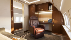 A private office area with a desk, shelving and leather seat.