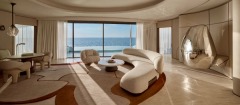 Curved living-room seating facing the pool and sea.
