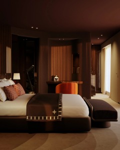 A softly lit bedroom framed by curved woodwork and rich upholstery.