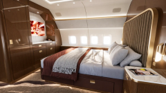 A private stateroom with a full bed and curved upholstered partition.