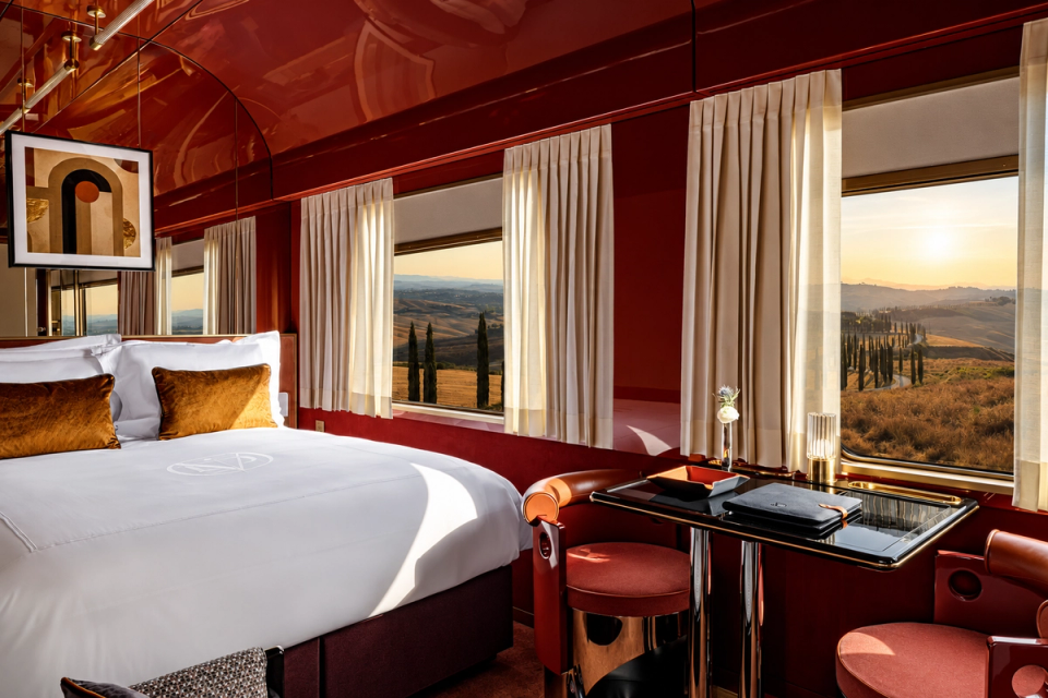A suite bedroom in deep red lacquer, looking toward the Italian landscape.