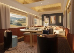 A bright sitting and dining area with sculptural ceiling details and a window-side sofa.