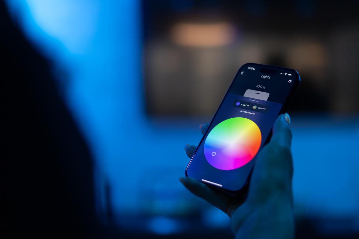 Josh App showing color wheel lighting control interface on iPhone in ambient lighting