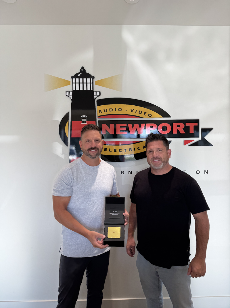 Two Newport AV employees pose with Gold Josh One.