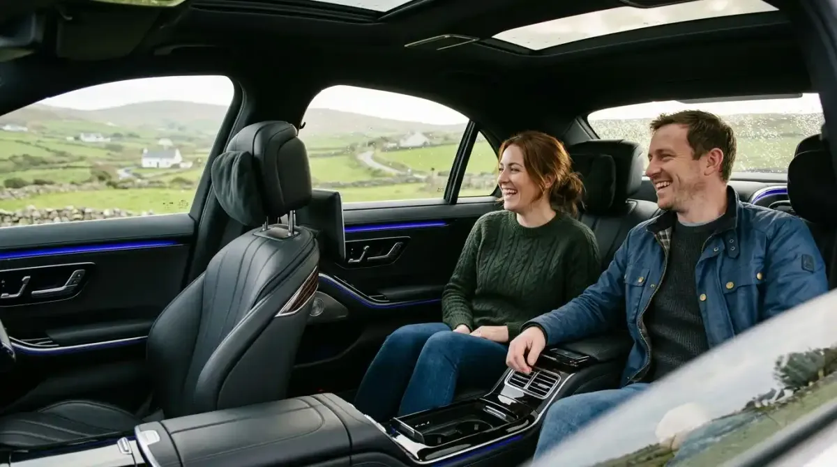 A couple enjoying the comfort of a private chauffeur-driven Mercedes during a luxury castle tour of Ireland.