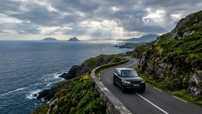 A luxury SUV navigating the scenic coastal roads of the Ring of Kerry with the Skellig Islands in the background.