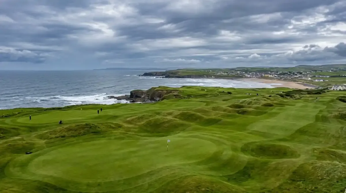 The pristine championship green of Lahinch Golf Club overlooking the wild coastal terrain of County Clare.