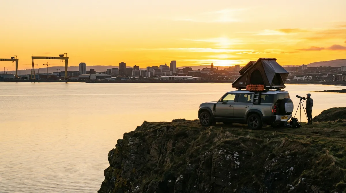 Modern car overlooking Belfast Lough with the city skyline at sunset.
