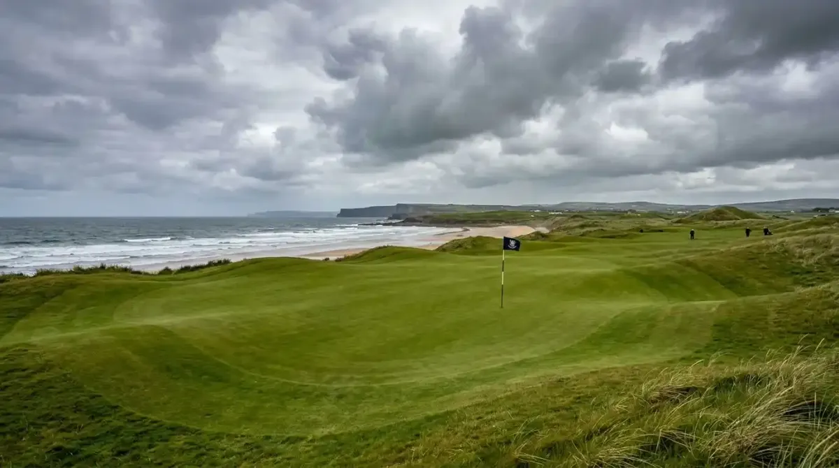 The manicured green of Lahinch Golf Club overlooking the rugged coastline of County Clare, Ireland.