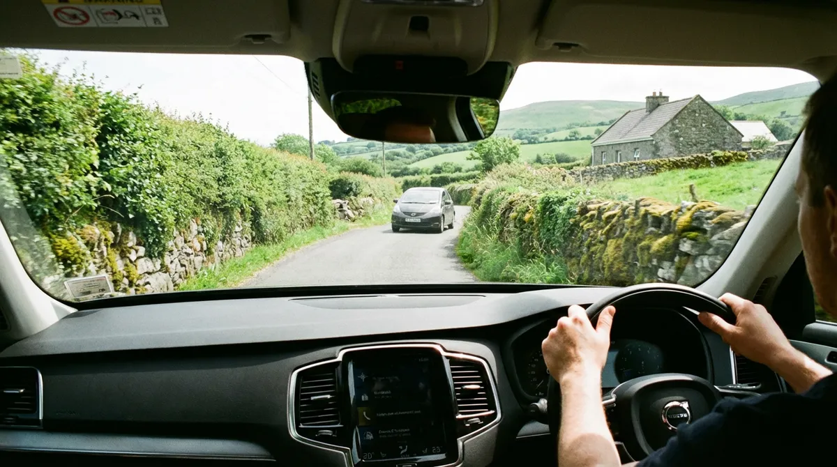Driver's view from a modern car on a narrow Irish road, showing driving on the left