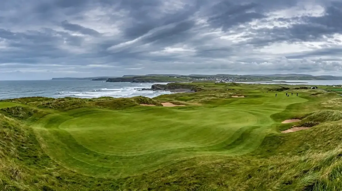 The pristine championship green of Lahinch Golf Club overlooking the wild coastal terrain of County Clare.