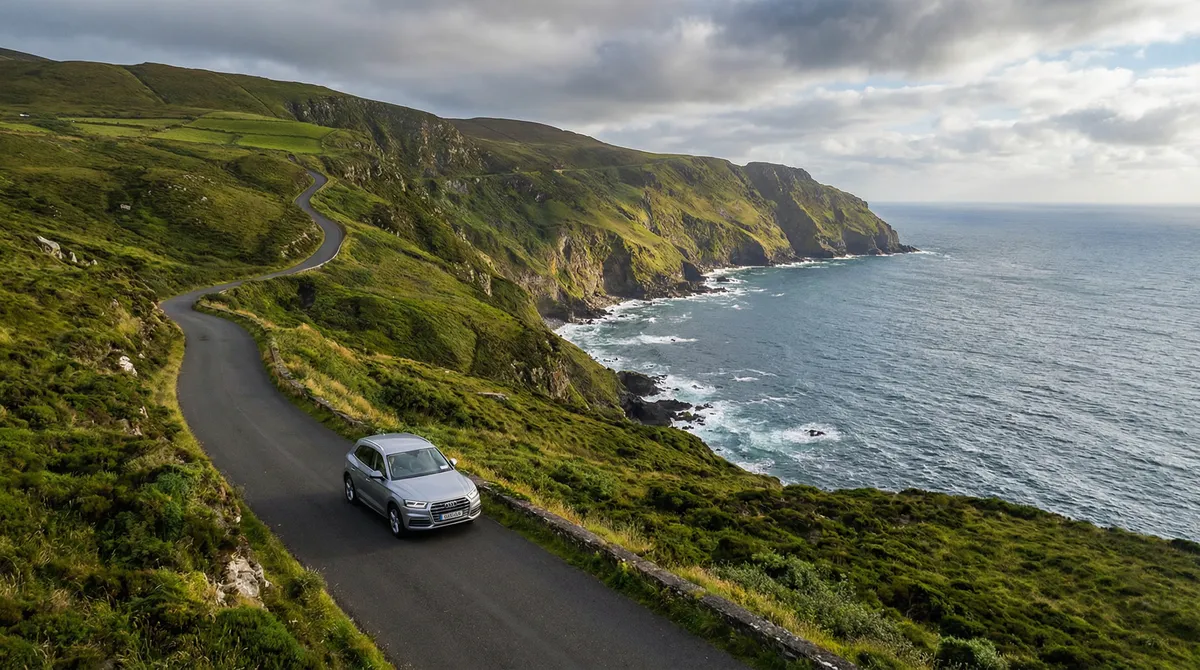 Modern rental car driving on a scenic coastal road in Ireland
