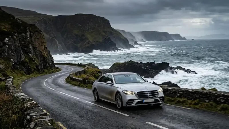 A luxury car navigating the scenic coastal curves of the Wild Atlantic Way in Ireland.
