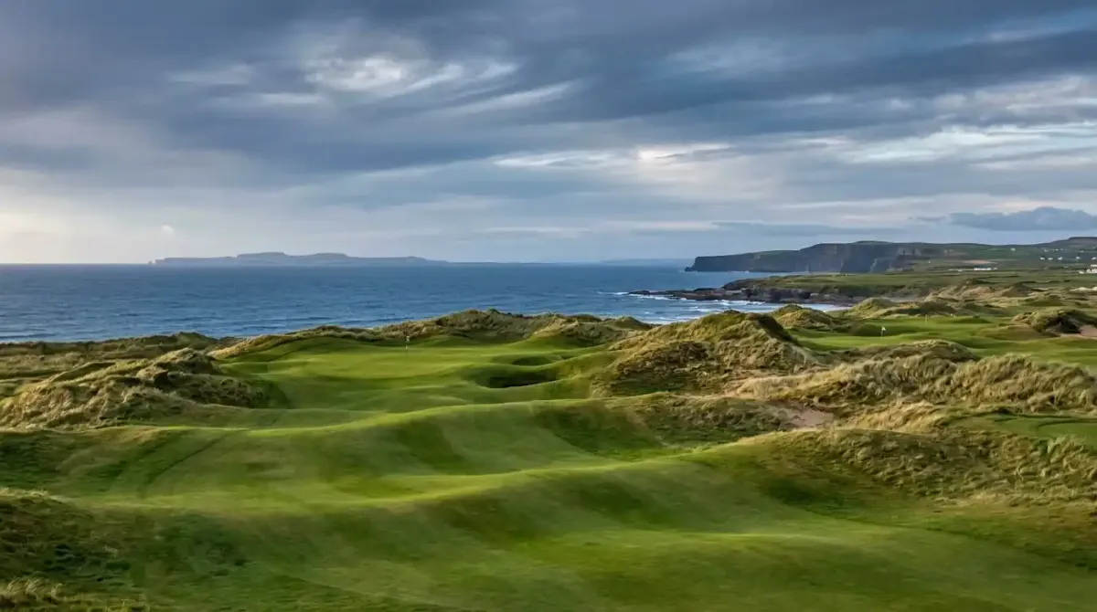 The pristine championship green of Lahinch Golf Club overlooking the wild coastal terrain of County Clare.