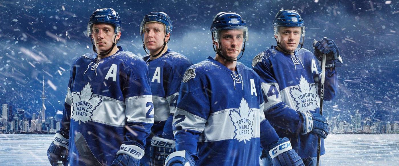 Four Toronto Maple Leafs players stand together in a dramatic snowy scene