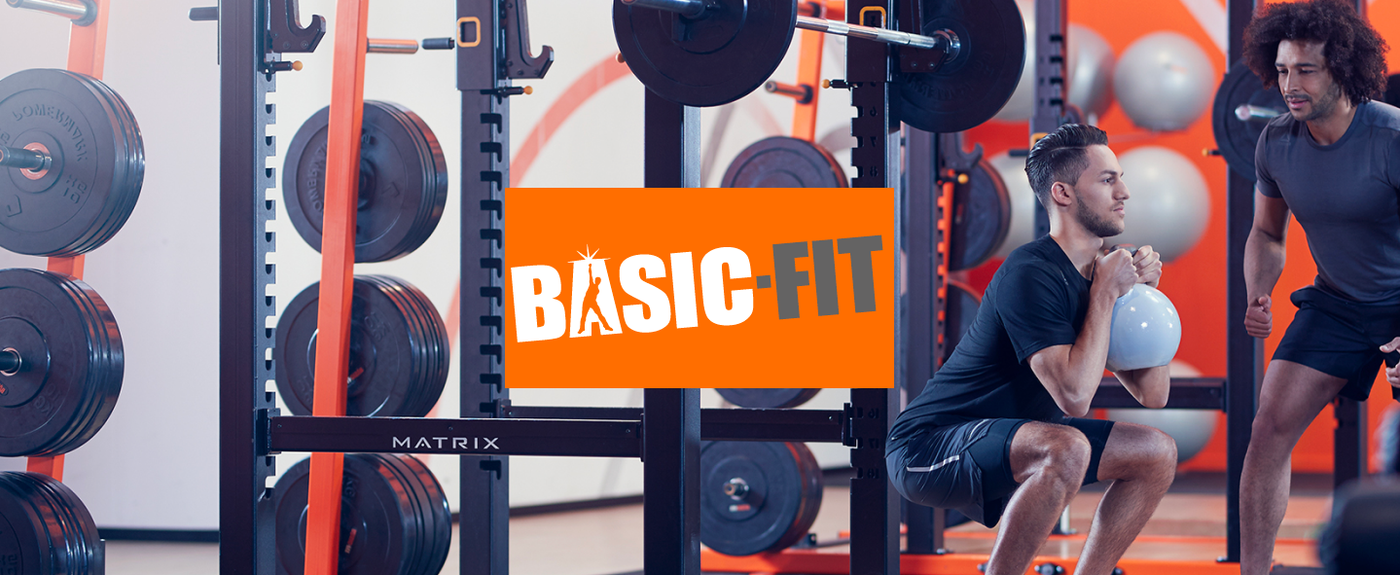 Basic-Fit gym interior with weight racks and members working out