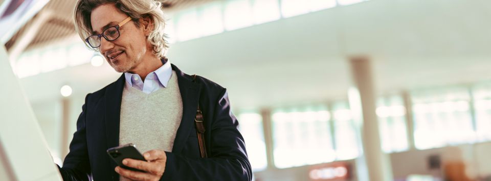 Businessman checking his phone in an airport terminal