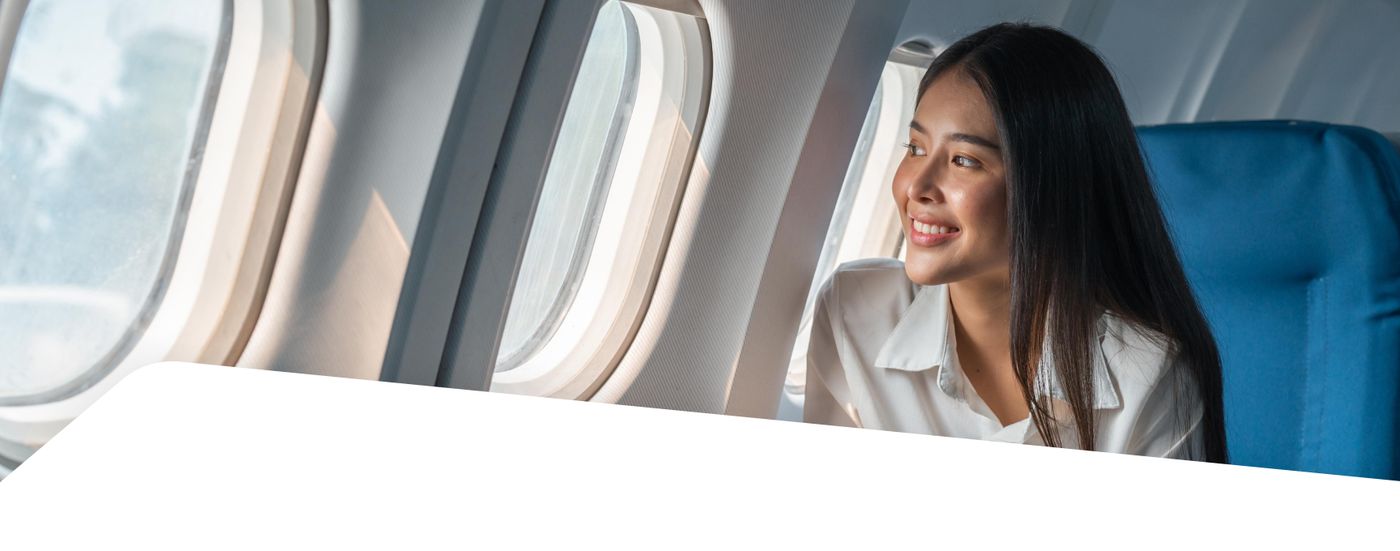Traveler smiling and looking out an airplane window
