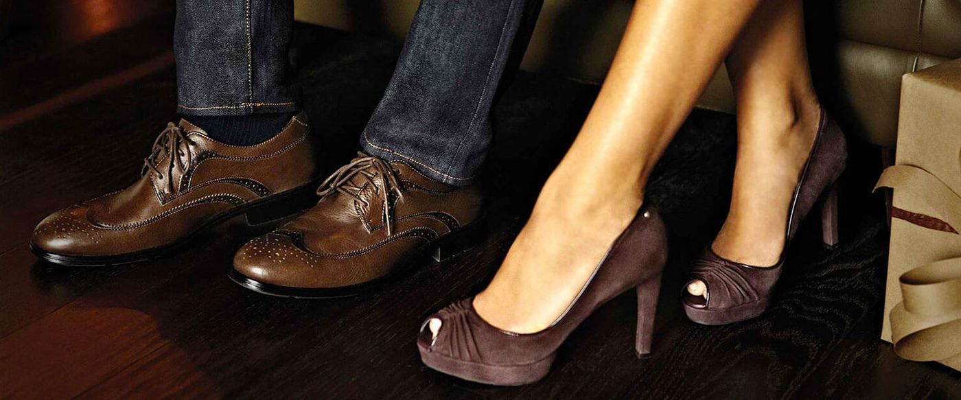 Close-up of a man's and woman's feet wearing Rockport dress shoes and heels