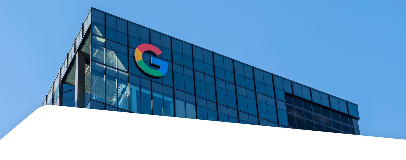 The Google logo on the corner of a glass office building
