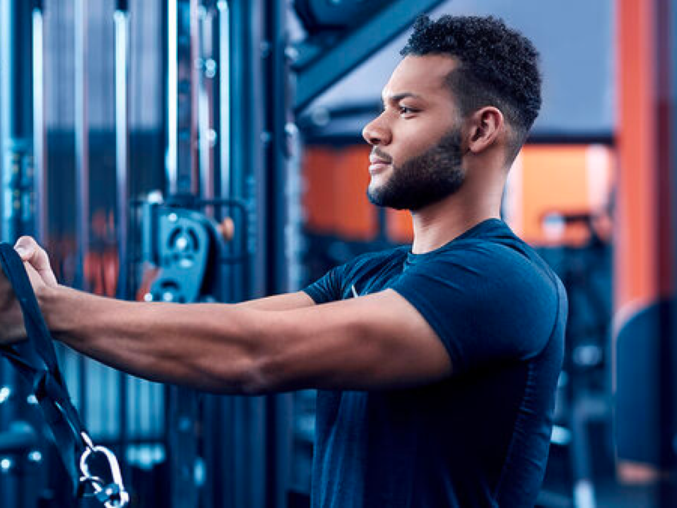 Man using cable machine equipment at a gym