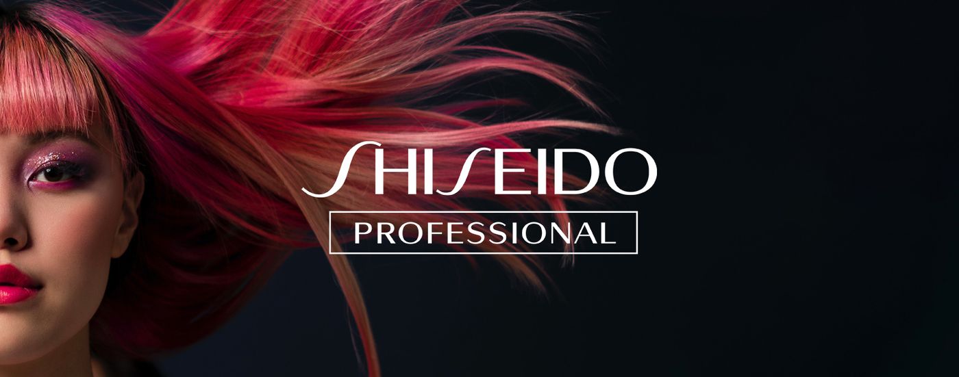 Model with vivid pink and red styled hair beside the Shiseido Professional logo
