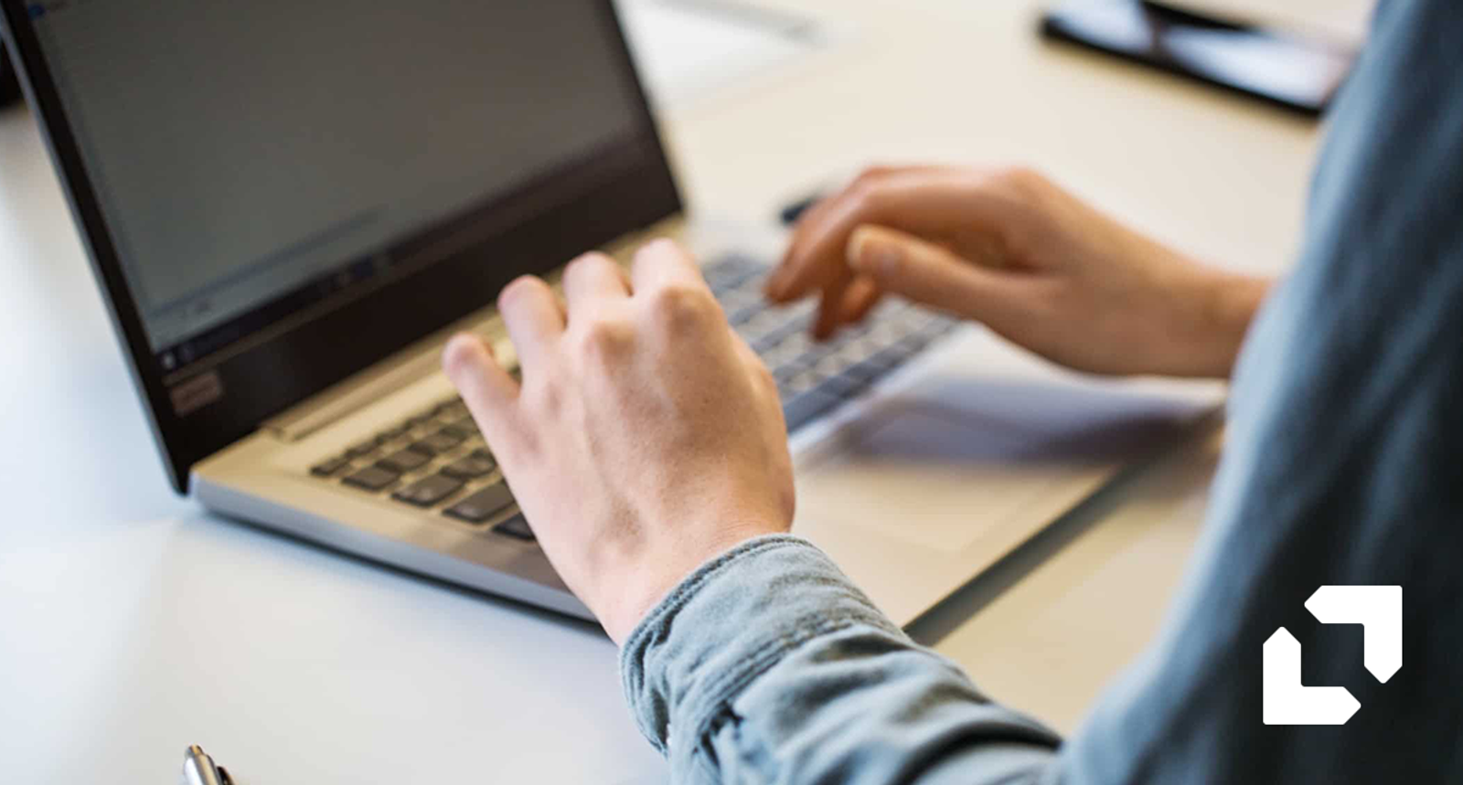 Close-up of hands typing on a laptop keyboard