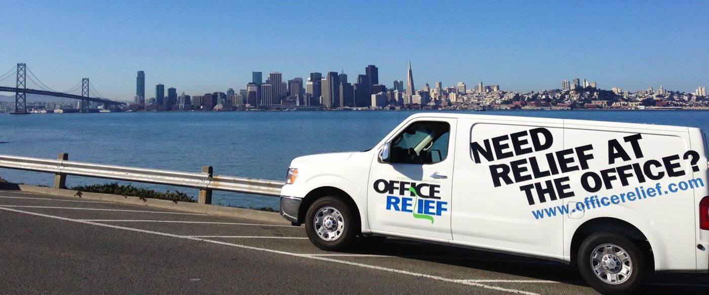An Office Relief branded van reading "Need relief at the office?" parked by the San Francisco waterfront