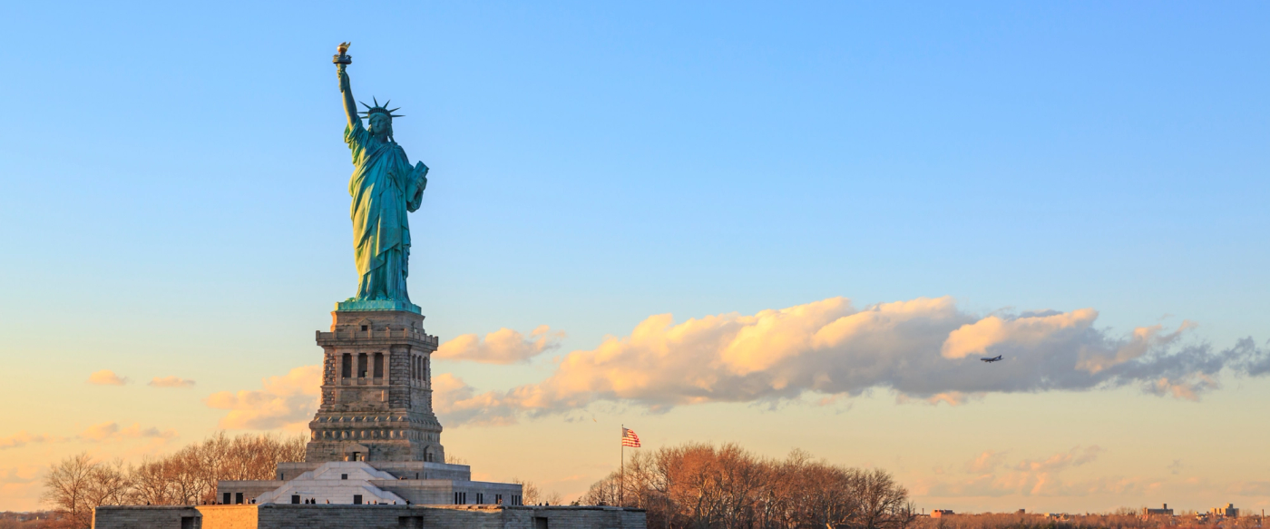 The Statue of Liberty against a sunset sky
