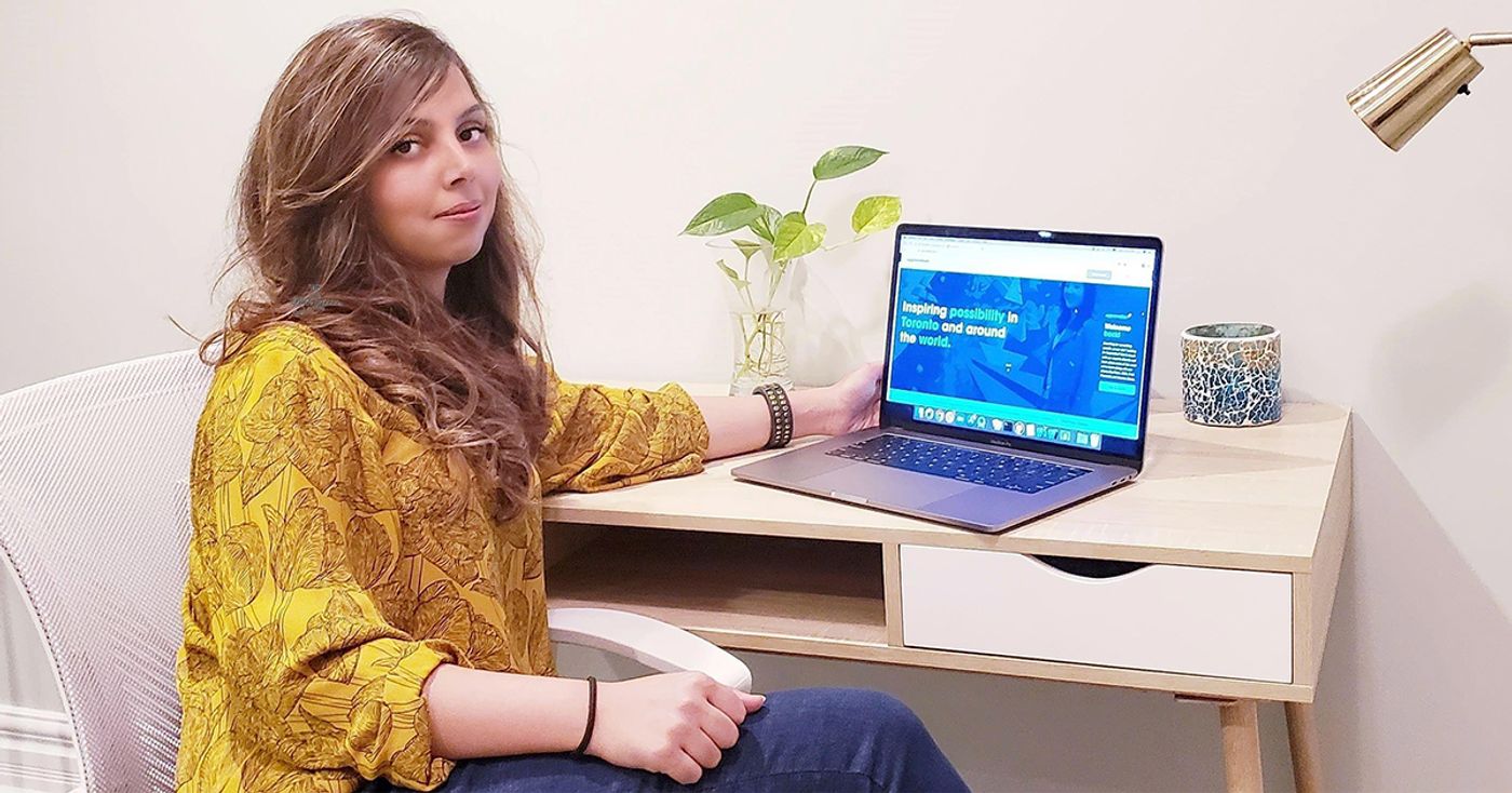 Shazmah Nawaz sitting at a desk at home beside an open laptop