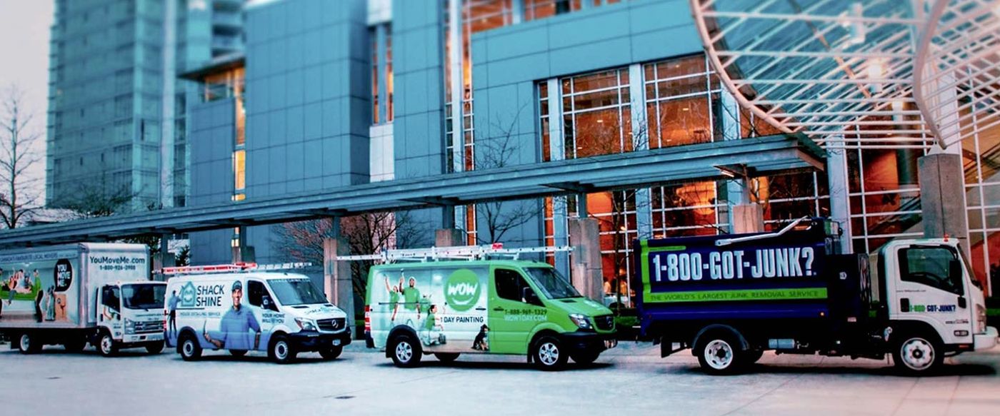 A lineup of O2E Brands service vehicles including 1-800-GOT-JUNK?, WOW 1 Day Painting and Shack Shine