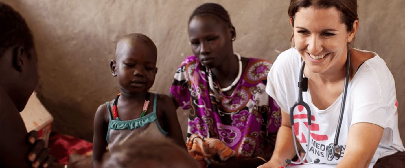 A Doctors Without Borders medical worker examines a child alongside her mother