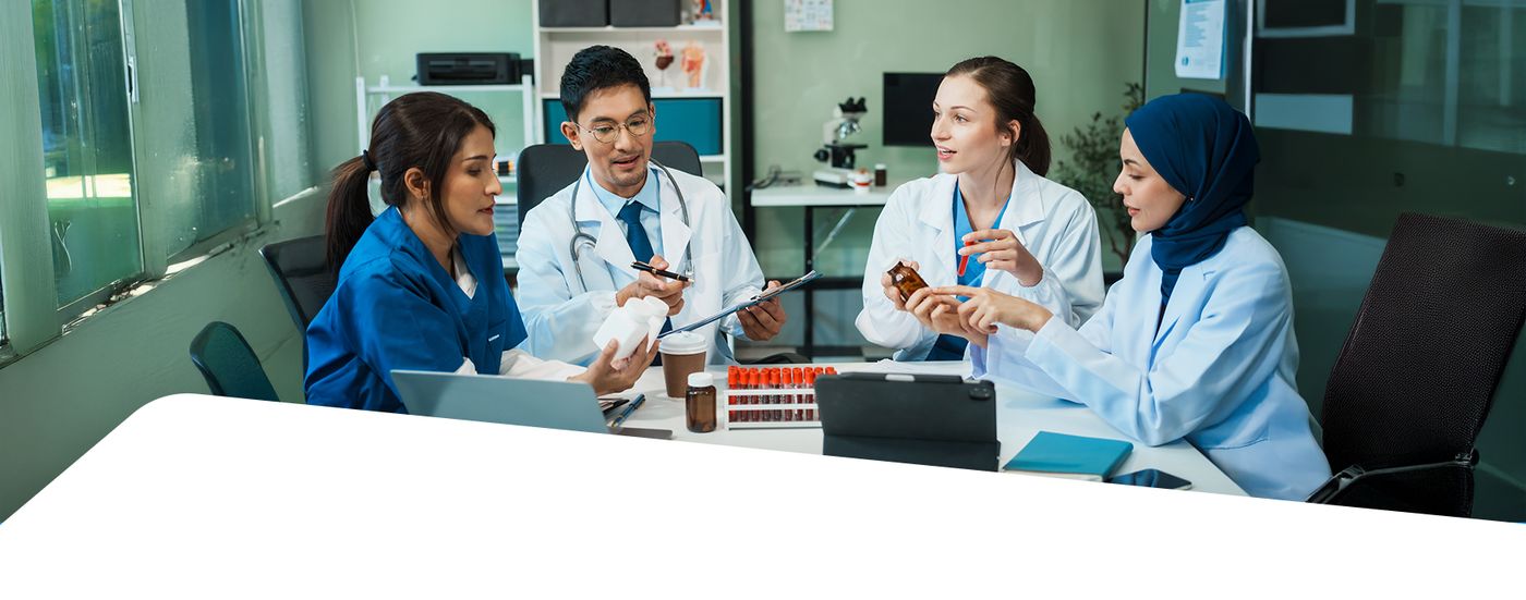 A team of doctors and nurses reviewing notes together around a table