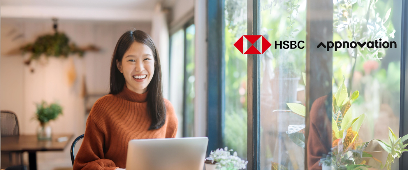 Smiling woman with a laptop in a bright cafe, next to the HSBC and Appnovation logos