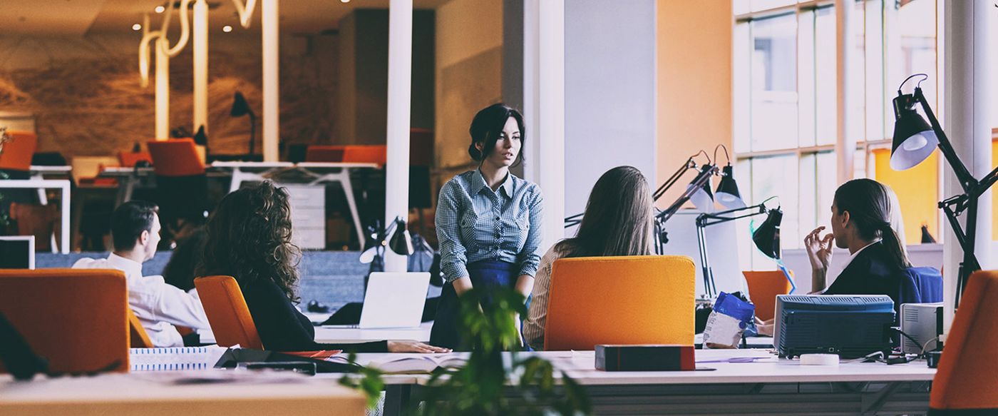 Colleagues collaborating at desks in an open-plan office