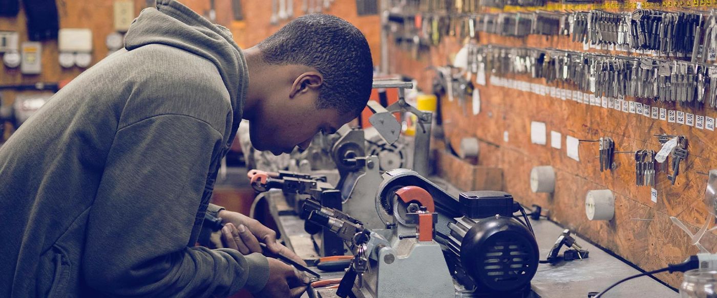Young trainee working on machinery at a workbench in a workshop