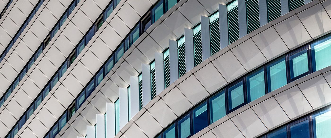 Close-up of a modern building's curved facade with rows of glass windows