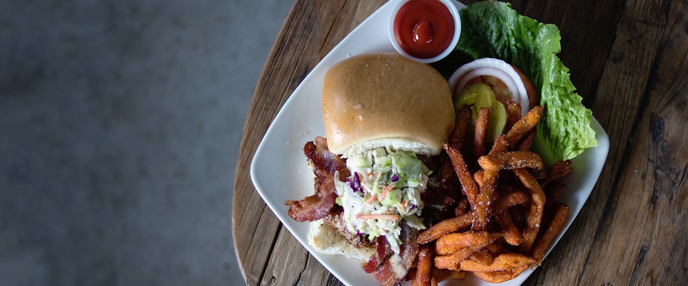Plated sandwich meal with sweet potato fries and coleslaw