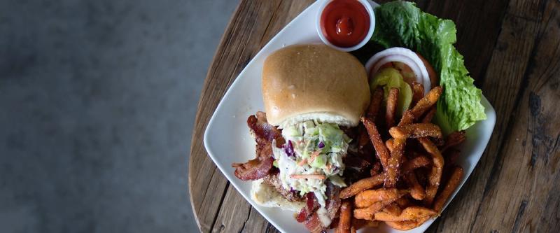 Plated sandwich meal with sweet potato fries and coleslaw