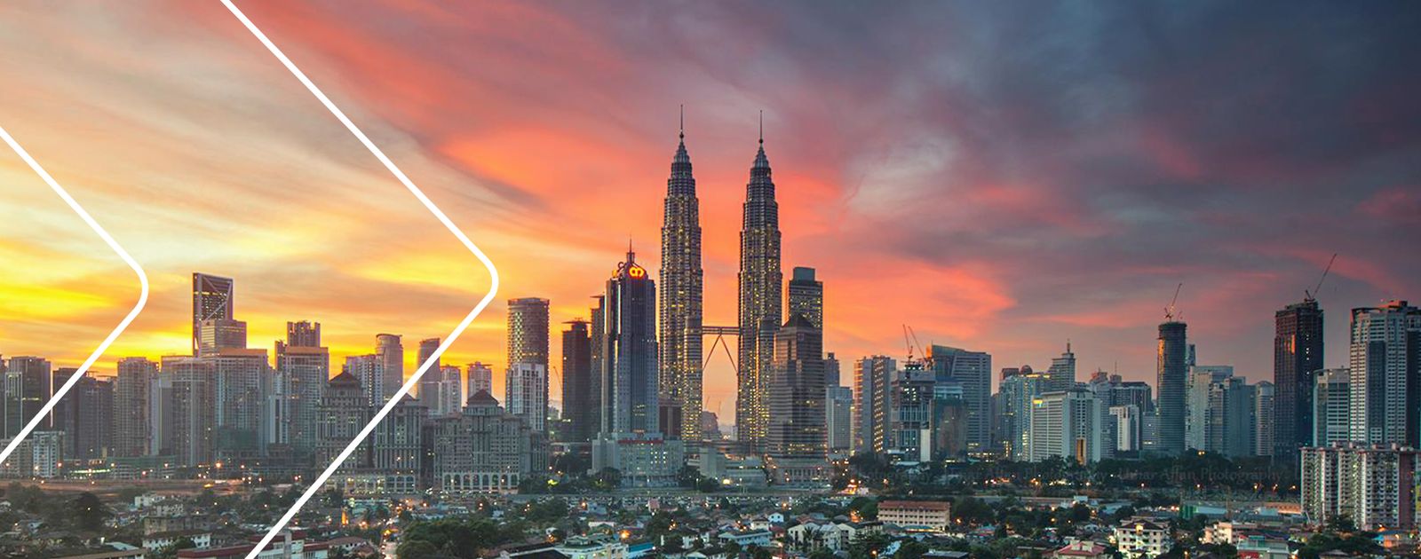 Kuala Lumpur skyline with the Petronas Towers silhouetted against a colourful sunset