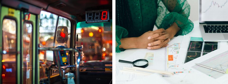 Bus driver's cab at night beside someone reviewing financial charts on a laptop