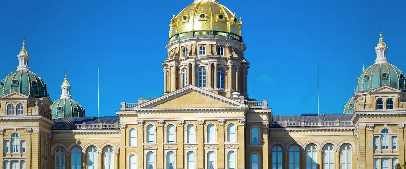 The Iowa State Capitol building with its golden dome under a clear sky